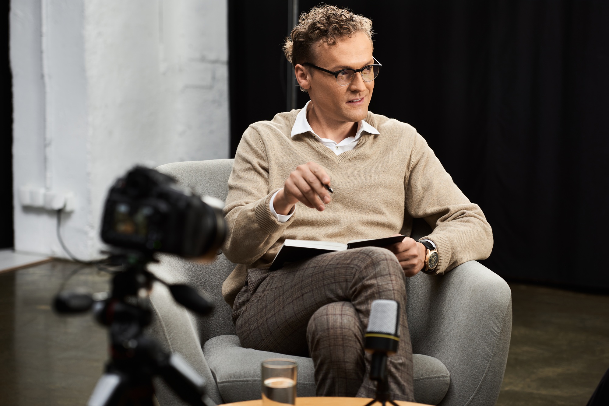 A journalist engages in a thoughtful interview in a studio